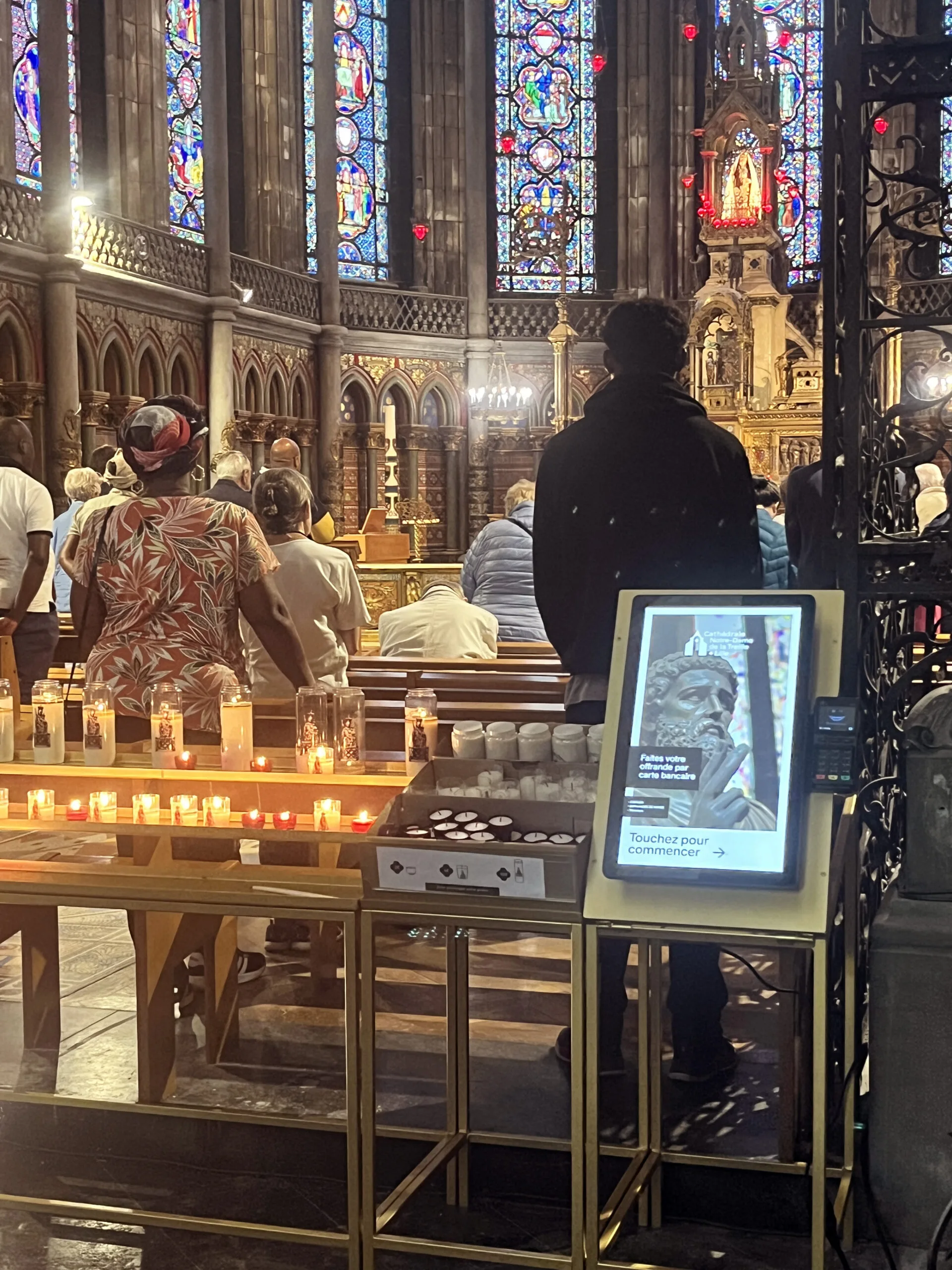 Borne de dons 6xPOS dans une église – Modernisez vos quêtes en toute discrétion Borne de dons 6xPOS installée dans une église avec fidèles en prière
